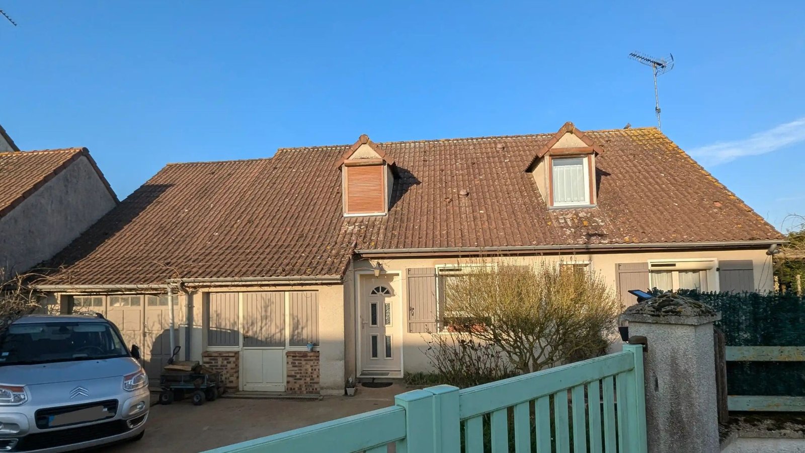 Toiture ancienne de 50 ans à Denonville avec tuiles poreuses et fort encrassement de mousses et lichens avant traitement.