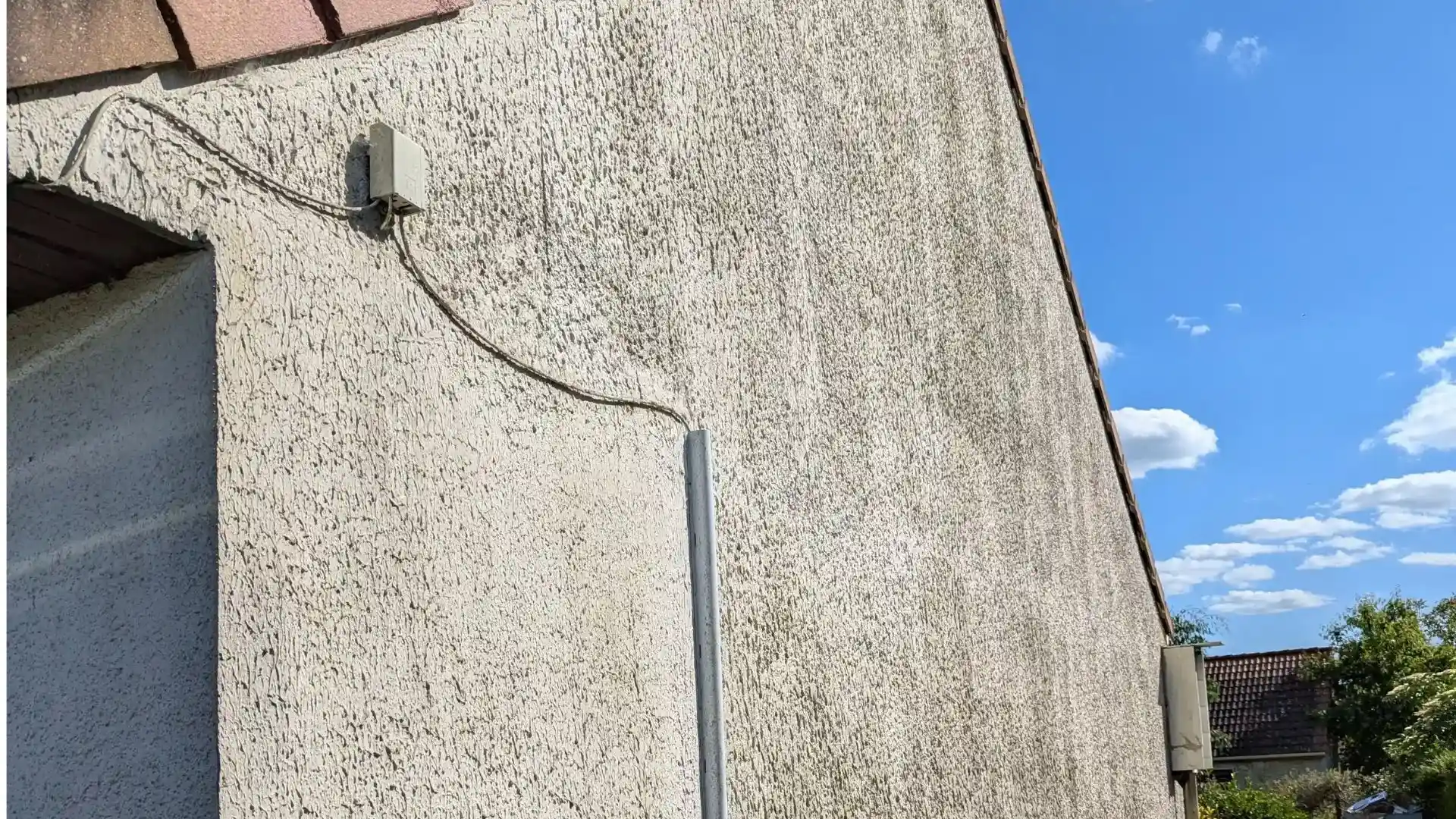 Photo avant ravalement du pignon à Ponthévrard montrant des plaques OSB défectueuses et un enduit fissuré