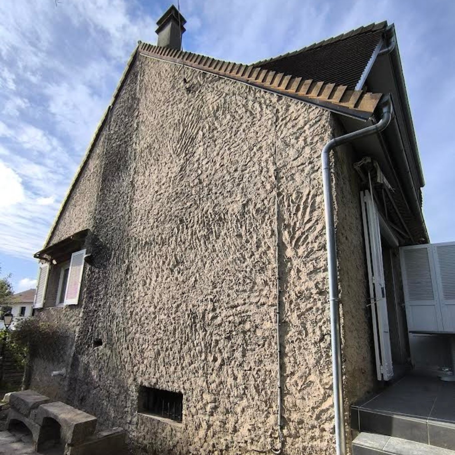 Photo de chantier avant ravalement : façade de maison de ville avec traces de pollution et enduit grisâtre