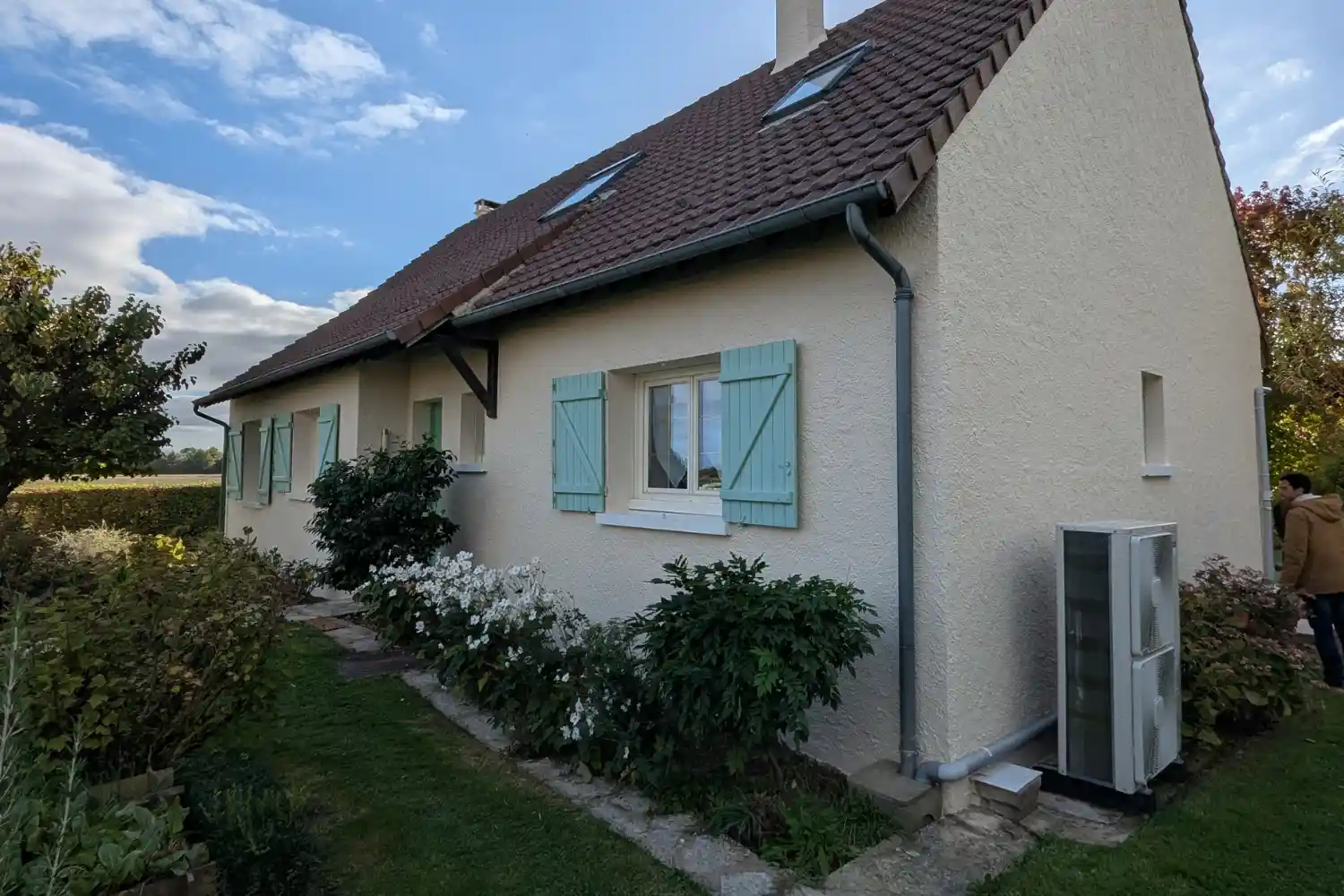 Ravalement de façade terminé sur maison individuelle à Ablis, crépi ton pierre et volets verts