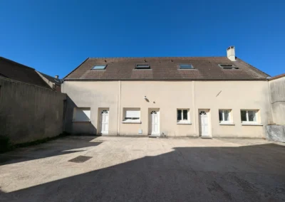 Cour interieure de limmeuble avant les travaux, montrant une longue facade dont le ravalement est fortement marque par les salissures et les coulures