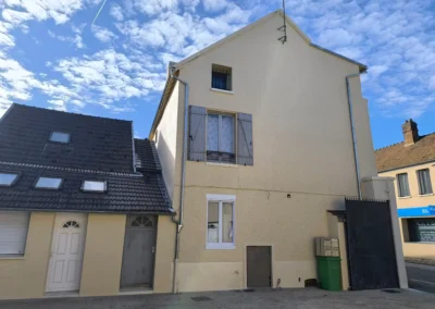 Facade laterale de limmeuble apres ravalement, affichant un mur propre traite en I1R et de nouvelles gouttieres en zinc