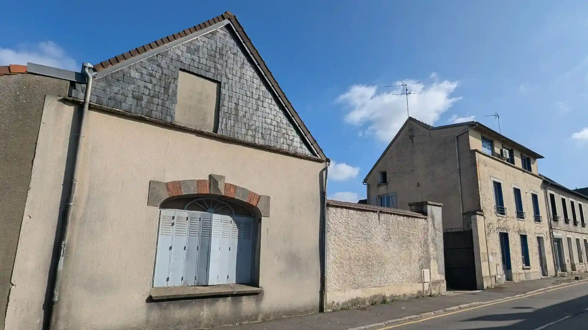 Vue depuis la rue de l immeuble vieillissant a Ablis avant travaux, avec des facades ternes et encrassees