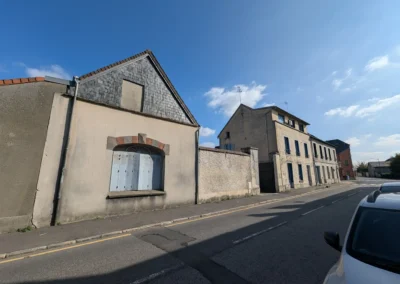 Vue depuis la rue de limmeuble vieillissant avant ravalement, avec des facades ternes et encrassees